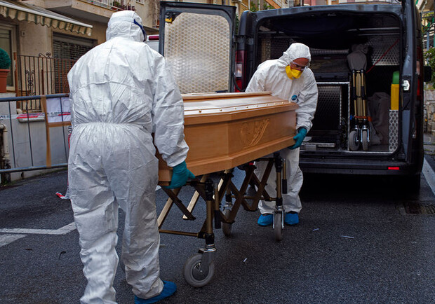 Медики во время транспортировки гроба с телом жертвы коронавируса в Лайгуэлье