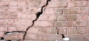 Трещины на фасаде и в квартирах: на Леваде рядом с коллектором разрушается дом