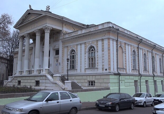 Работники старинного музея в Одессе красят фасад здания зеленой краской. 