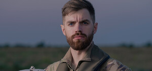 Люди несут цветы к муралу 