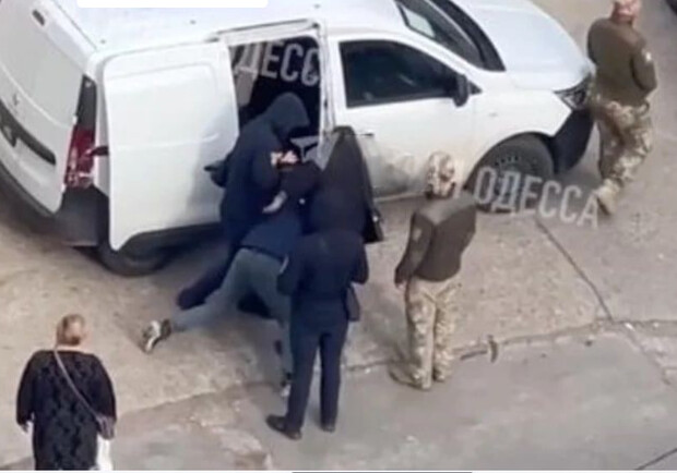 В Одесі працівники ТЦК одягли наручники на чоловіка та затягли його в бус. 