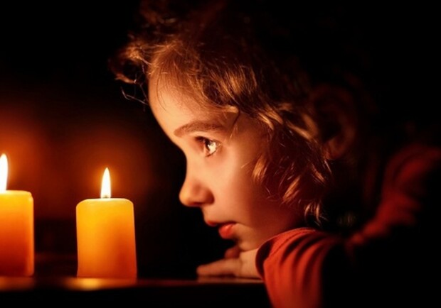 Девочка смотрит на свечу. 
