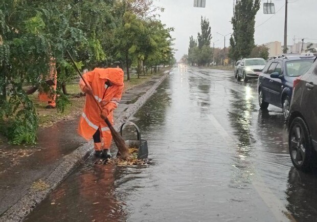 Коммунальщик работает на затопленной улице. 