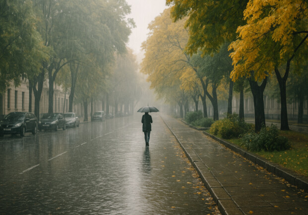 Жінка йде під дощем восени. 
