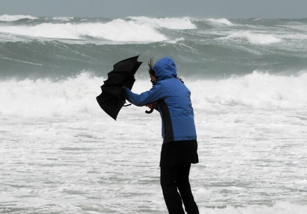 Мужчина на берегу моря во время шторма. 