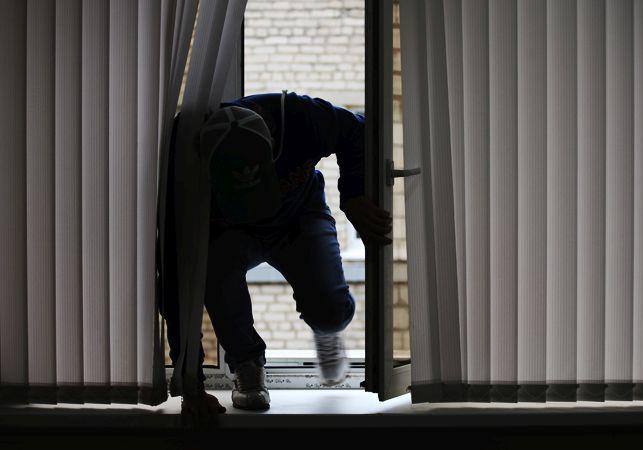 Домушник лезет через окно Фото: Новости