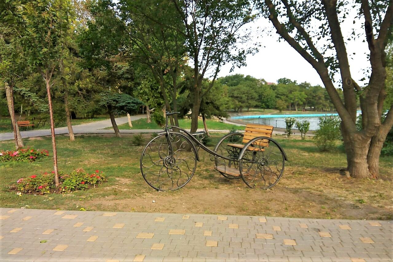 Велосипед-колесница возле пруда