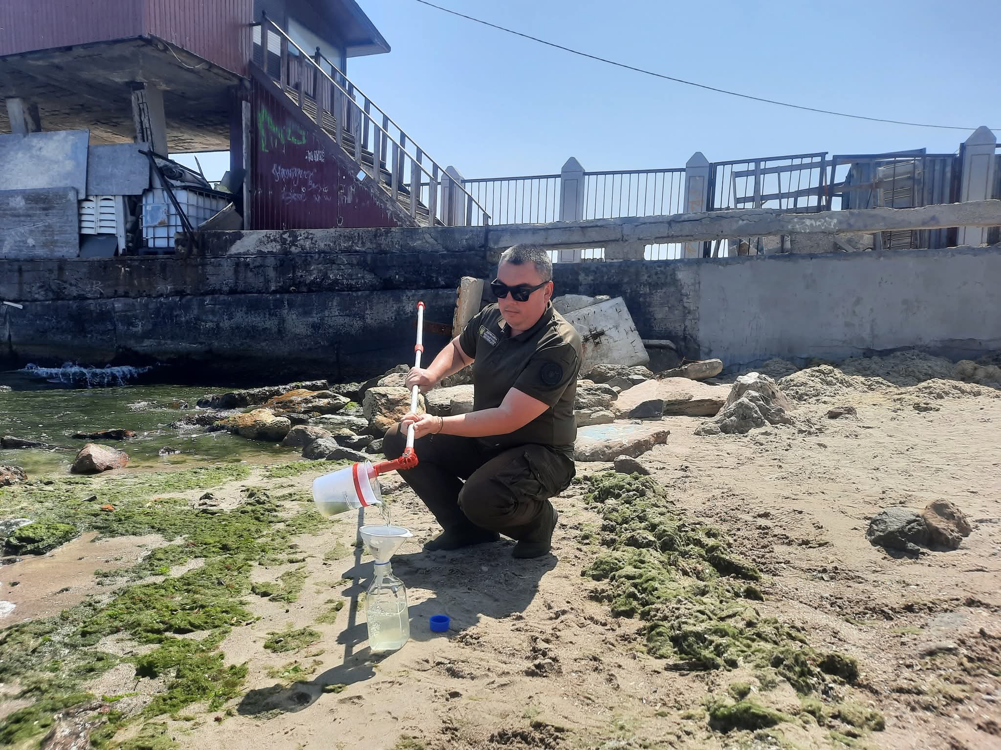 Еколог відбирає проби морської води.