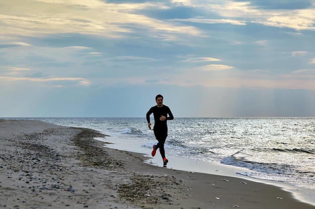 Чоловік біжить берегом.