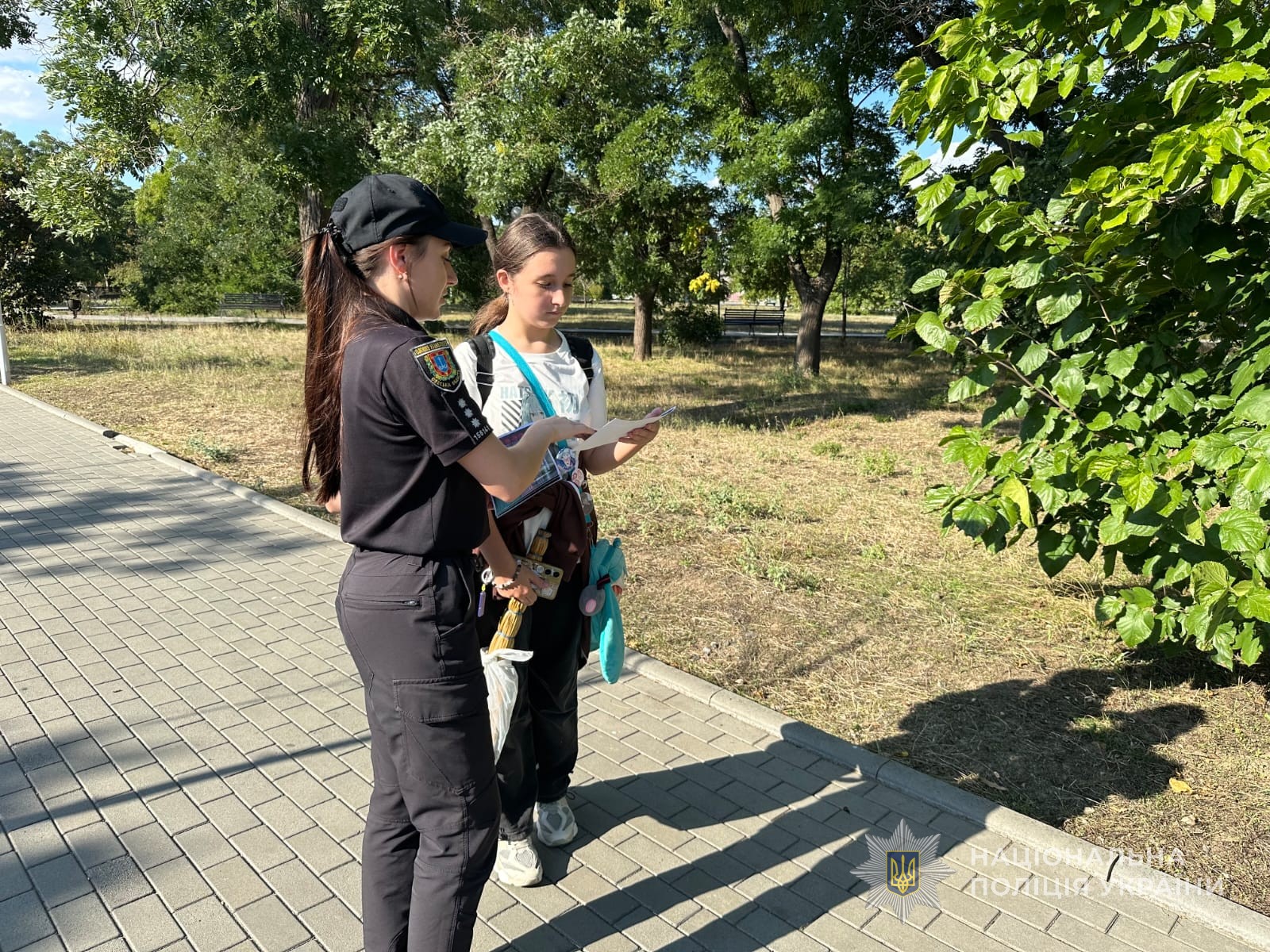 Поліцейська спілкується з дівчиною.