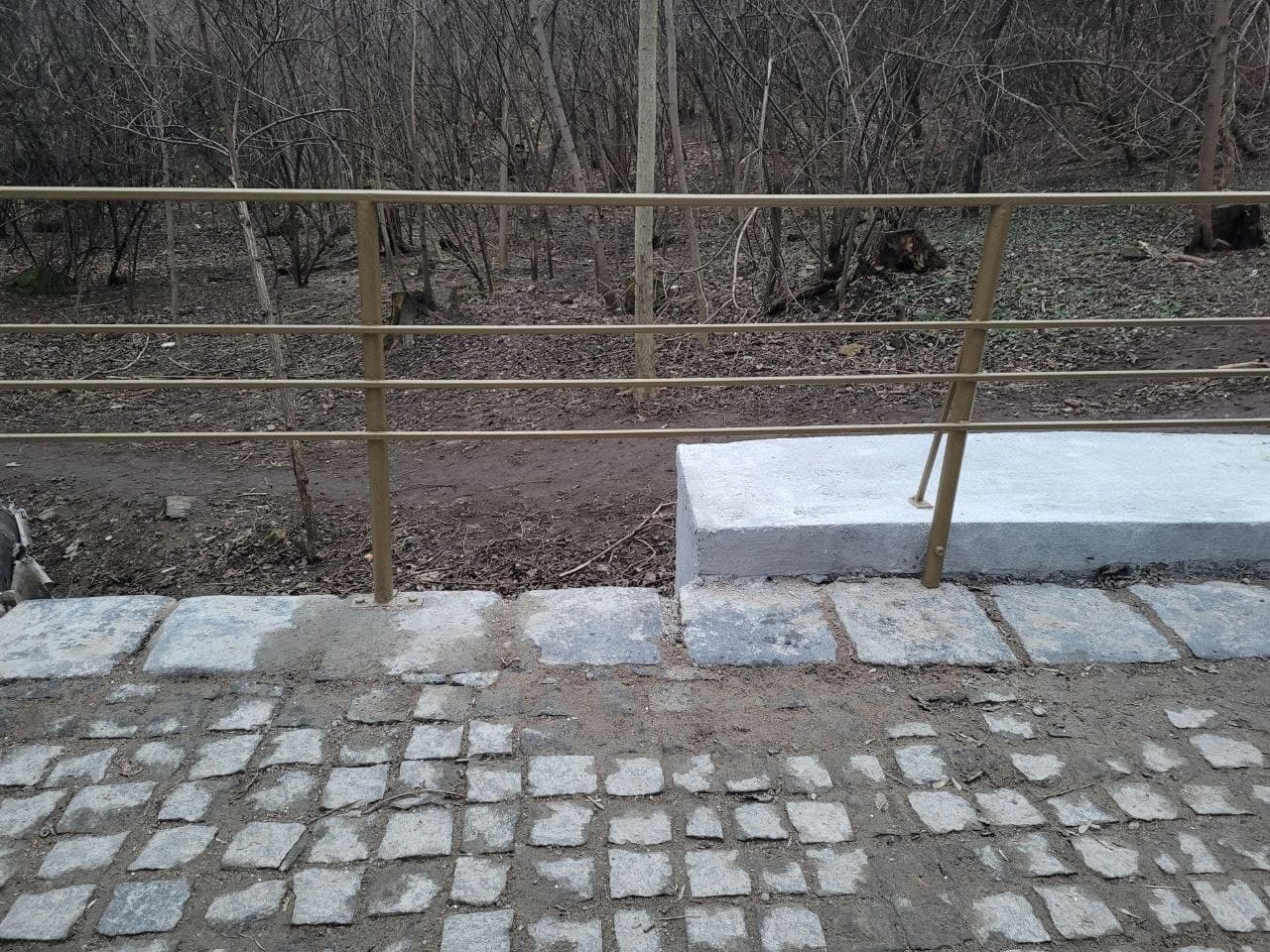 Пролеты лестницы вымостили колотой гранитной брусчаткой.