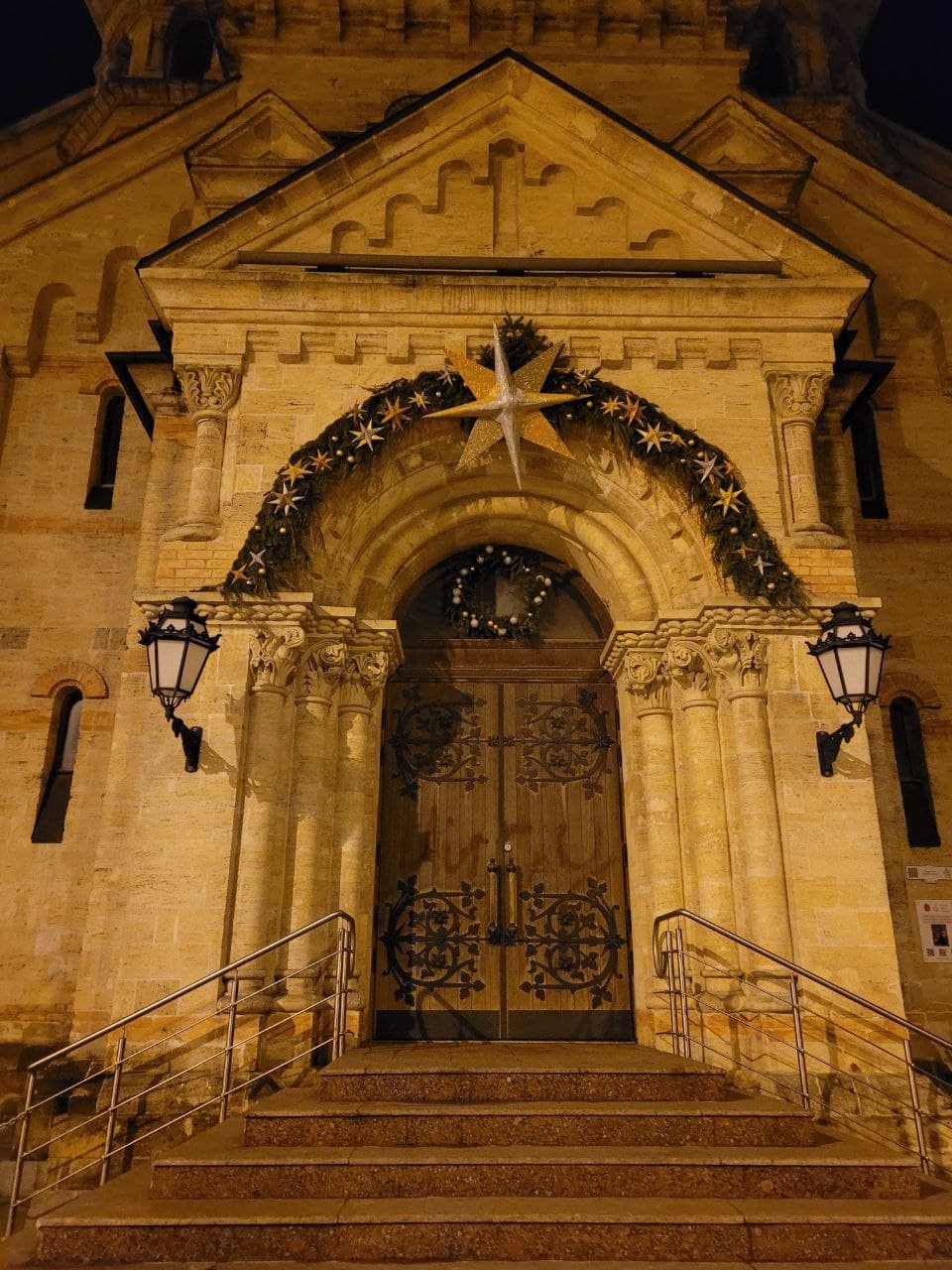 Вход в Кирху украшен еловыми ветками и рождественскими звездами.