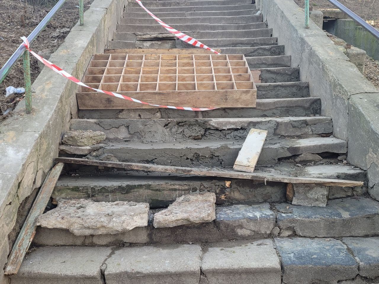 Участок лестницы зацементировали и оградили деревянной перегородкой.